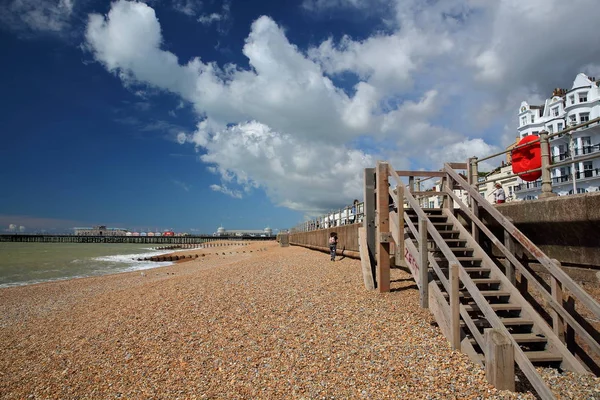 Hastings, İngiltere - 23 Temmuz 2017: Arka plan ve mavi gökyüzü güzel bulutlar ile İskele (yeniden inşa edildi ve 2016 yılında halka açık) ile renkli plaj