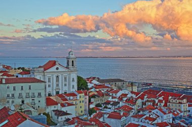 Santa Luzia bakış açısı (miradouro) üzerinde Santa Estevao Kilisesi, Tagus Nehri ve renkli bir gökyüzü, Lizbon, Portekiz ile Alfama mahalle manzaralı günbatımında