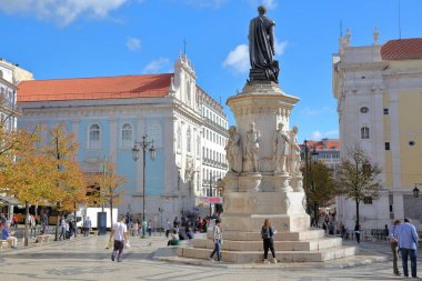 LISBON, PORTUGAL - NOVEMBER 4, 2017: Camoes Square in Bairro Alto neighborhood with Luis de Camoes poet statue and two churches (do Loreto on the left and da Nossa Senhora da Encarnacao on the right) in the background. The shooting date is November 4 clipart