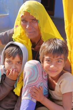 Bundi, Rajasthan, Hindistan - 09 Aralık 2017: Renkli elbise Bundi yakın bir köyde iki çocuklu poz ile yaşlı bir kadın portresi
