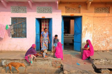 Chittorgarh, Rajasthan, Hindistan - 14 Aralık 2017: Kadın ve çocukların geleneksel ve renkli evlerinin önünde sokak sahne