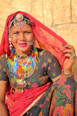 Jaisalmer, Rajasthan, Hindistan - 21 Aralık 2017: Portre ile güzel bir kadının gözleri açık ve geleneksel renkli sari ve mücevher Jaisalmer kale girişindeki ile giyinmiş 
