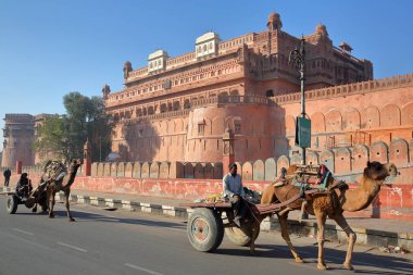 Bikaner, Rajasthan, Hindistan - Aralık 23, 2017:2 arabaları Junagarh Fort önünde deve ile 