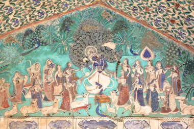 Bundi, Rajasthan, Hindistan - 08 Aralık 2017: gopi, ağaçlar ve arka planda tavus kuşu ile çevrili flüt çalmaya Krishna betimleyen duvar resimleri Chitrasala Bundi Sarayı (Garh) adlı