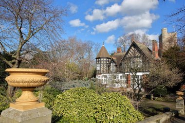 LONDON, UK - FEBRUARY 18, 2018: Pryor's Bank, a Gothic House in Fulham, Bishops Park, borough of Hammersmith and Fulham. With the tower of All Saints Church in the background clipart