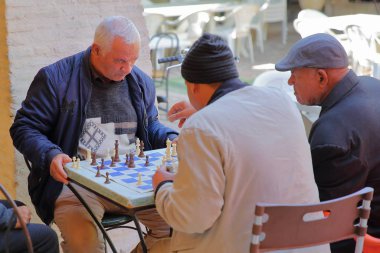 TOZEUR, TUNISIA - DECEMBER 19, 2019: Locals playing chess inside a cafe in Tozeur