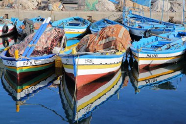 Mahdia, Tunus - 27 Aralık 2019: Balıkçı limanındaki renkli balıkçı tekneleri ve yansımaları