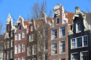 Hollanda, Amsterdam 'daki Brouwersgracht Kanalı boyunca yer alan, gable çatıları olan renkli miras binalarına yakın plan.