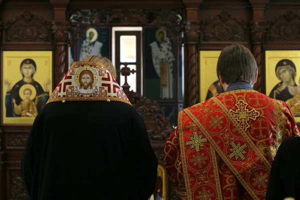 Obispo ortodoxo y archidiácono orando delante del altar — Foto de Stock