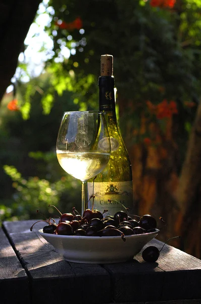 Gürcistan kırsalında güneş ışığı ışınlarında kiraz ile bir bardak beyaz şarap Telifsiz Stok Imajlar