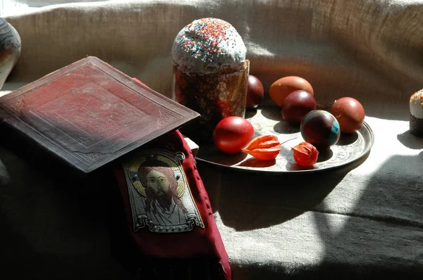 Das Osterstillleben mit der Heiligen Bibel, Osterkuchen und gefärbten Eiern — Stockfoto