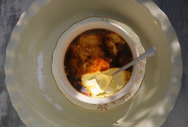 Parlak güneş ışığı altında bir beyaz porselen fincan lezzetli pannacotta