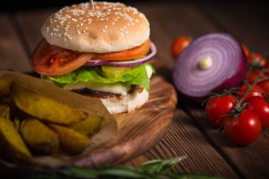 Büyük iştah açıcı burger sığır eti, patates ve peynir bir ahşap yüzeye
