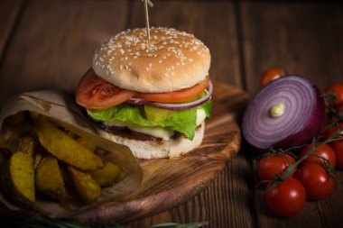 Büyük iştah açıcı burger sığır eti, patates ve peynir bir ahşap yüzeye