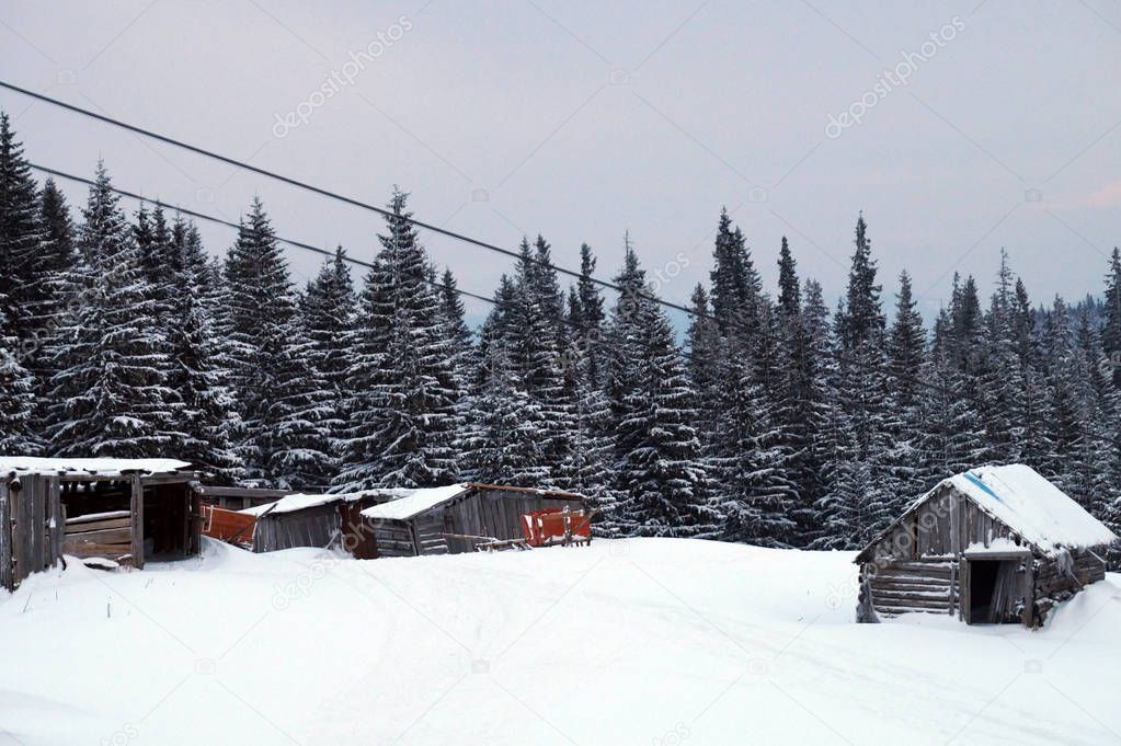 Little houses on the snowy mountain peak in the morning. Snow-covered mountain in Carpathians, Ukraine