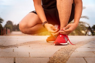 Onun koşu ayakkabıları sağlıklı kavramı günbatımı ışığı içinde bağlama üzerinde erkek el kadar kapatın