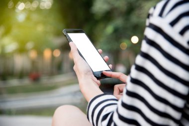 Holding ve açık parkta holid akıllı telefon kullanan kadın