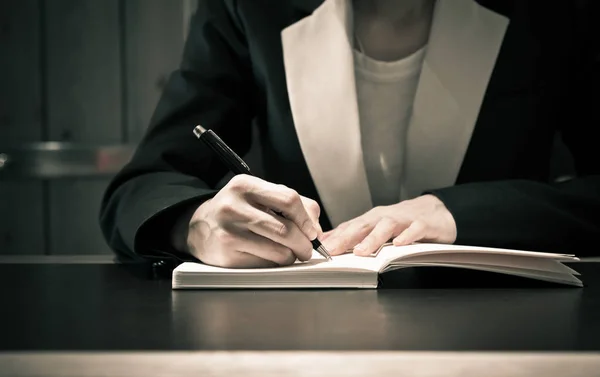 Közel üzletemberek kéz a kézben írnak a füzetben vagy a dokumentumban — Stock Fotó
