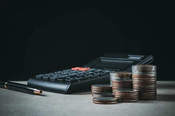 Rij van munten, pen en calculator op de houten tafel in Financiën een — Stockfoto