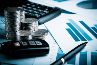 Araç finans ve bankacılık konsepti hesap defterinde bozuk para, uzaktan kumanda ve kalem satışı.