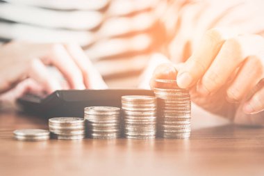 İnsanların el işi hesap makinesi ve para, finans bankacılığı ve tasarruf kavramında madeni paralar