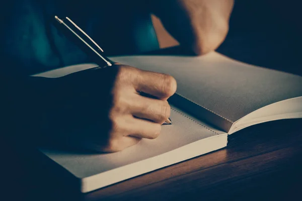 Close up de pessoas mão escrevendo no notebook na mesa de madeira — Fotografia de Stock
