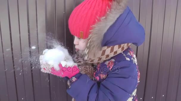 Το παιδί είναι φυσά πάνω στο χιόνι, φυσάει χιόνι από της φοίνικες — Αρχείο Βίντεο