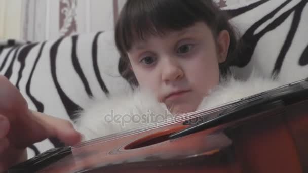 Hermosa niña ha estado entrenando para tocar la guitarra — Vídeo de stock