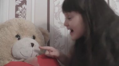 Küçük kız ayı burun ile oynuyor. Burun losyonları