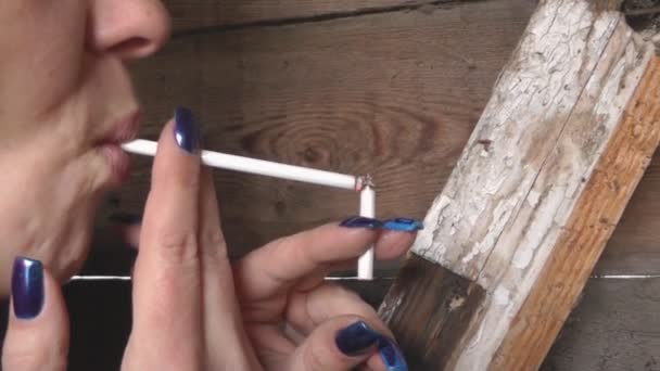 Женщина с красивым маникюром, держащая сигарету, курит — стоковое видео