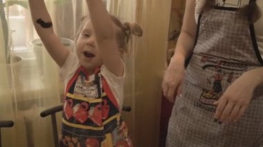 Kız ve annesi zeytin bir kolye üzerinde çalışıyor