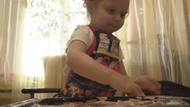 Kind legt Bratwurst-Pizza auf die Pfanne — Stockvideo