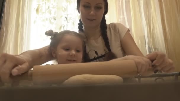 Mamá con una chica con un rodillo rodar la masa — Vídeo de stock