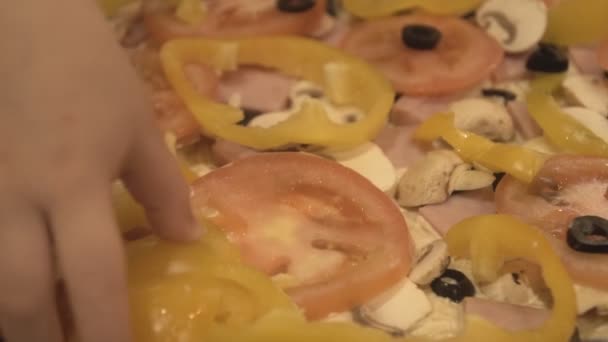 A Child's Hand Puts a Topping on Homemade Pizza — Stock Video