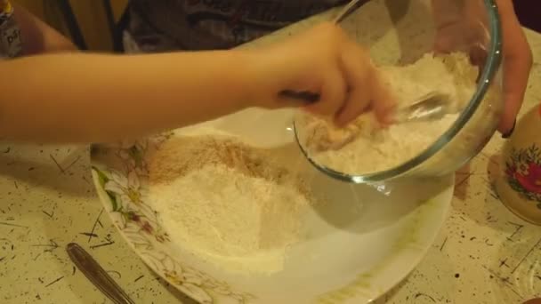 Aus der Schüssel gießt die Hand der Kinder das Mehl — Stockvideo