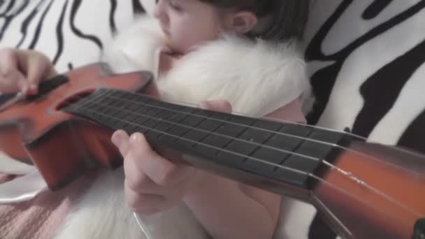 Yung dziewczyna uczy się grać na gitarze — Wideo stockowe