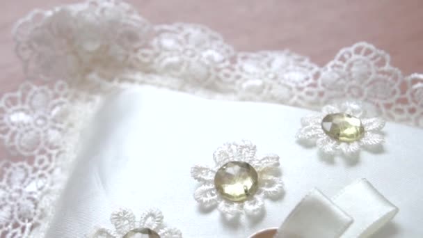 婚戒在白色的枕头上。 婚礼活动的概念- -两个金戒指和蓝色缎带的蝴蝶结. — 图库视频影像