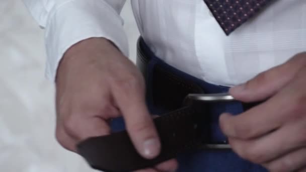 Un homme attache une ceinture noire sur son pantalon — Video