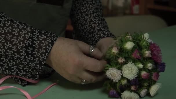Ανθοπωλείο συλλέγει ένα μπουκέτο από φρέσκα λουλούδια με τα χέρια του — Αρχείο Βίντεο