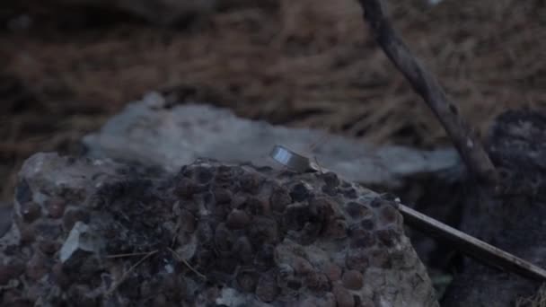 homme conduit un bâton aux pierres dans le feu éteint 