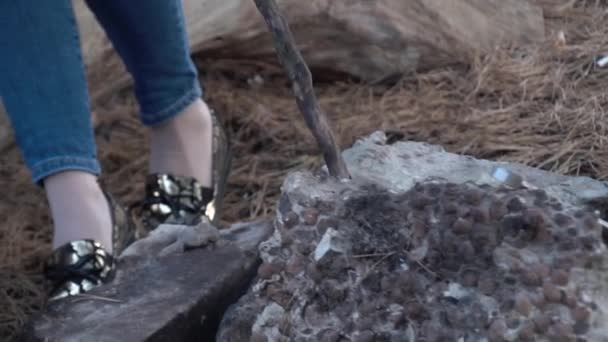 Hombre conduce un palo en las piedras en el fuego extinto — Vídeos de Stock