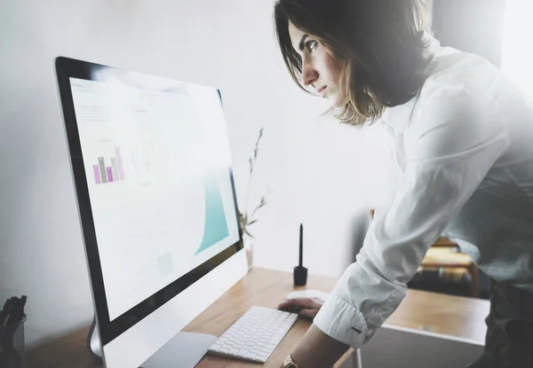 นักธุรกิจหญิงในเสื้อสีขาว มองไปที่คอมพิวเตอร์ — ภาพถ่ายสต็อก