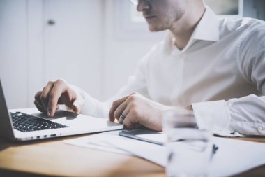 Ofiste dizüstü bilgisayarda çalışan iş adamı.