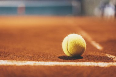 Yellow tennis ball on empty court
