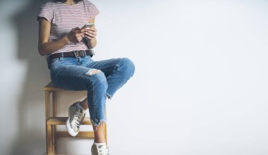 Char üzerinde oturan ve modern smartphone kullanarak kız