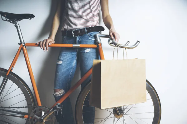 woman with vintage bike and paper package