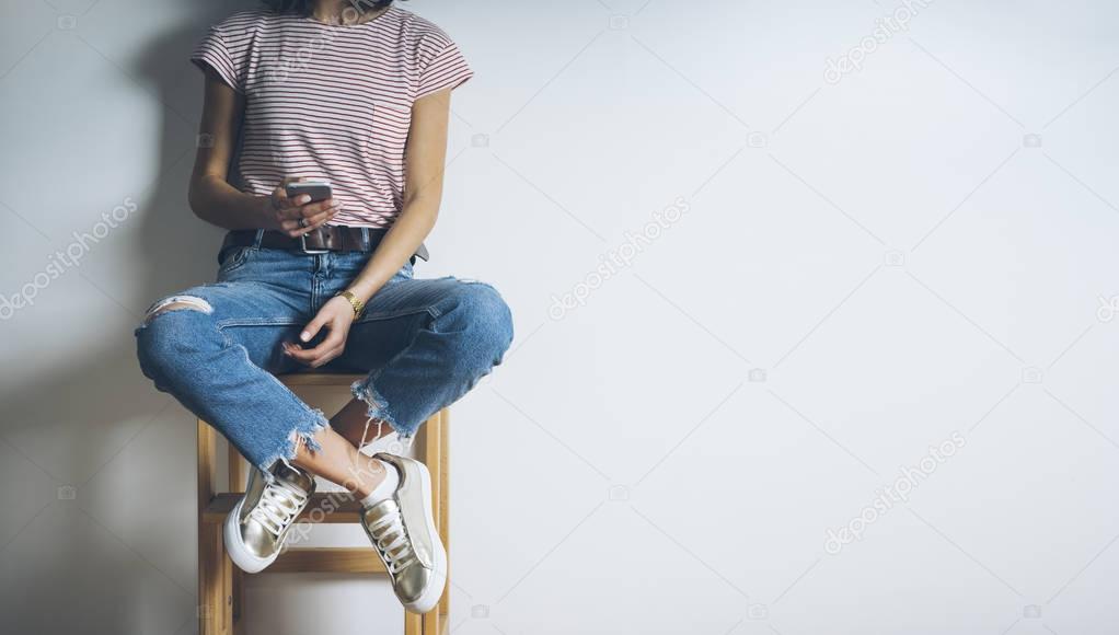 girl sitting on char and using modern smartphone