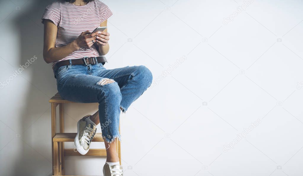 girl sitting on char and using modern smartphone
