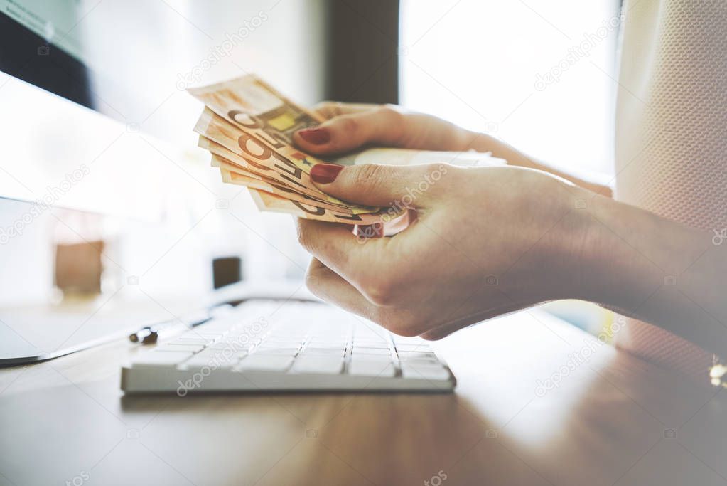 female hands counting euro bills