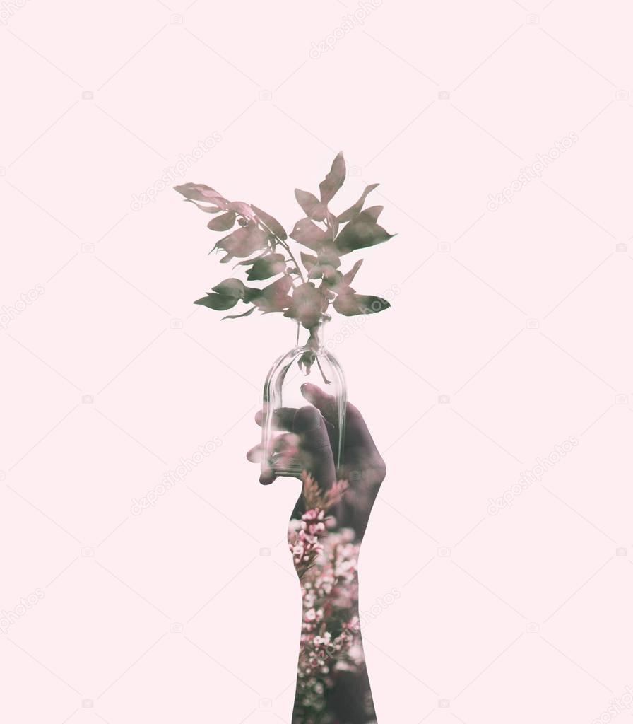 hand holding jar with pink branch 
